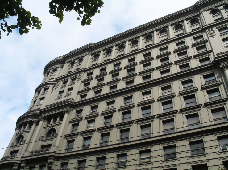 a very large grey building sitting below a blue cloudy sky