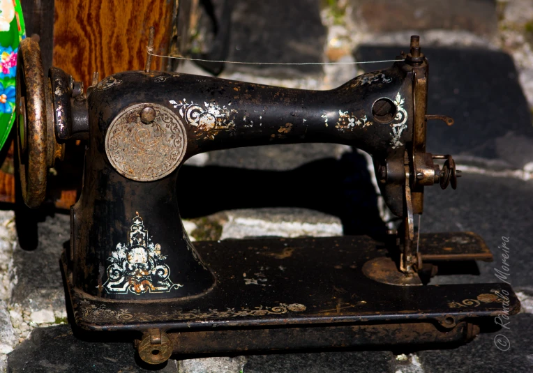 a black sewing machine with an old wooden handle