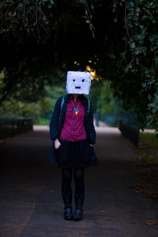 a person wearing a paper cutout hat and dark colored clothes