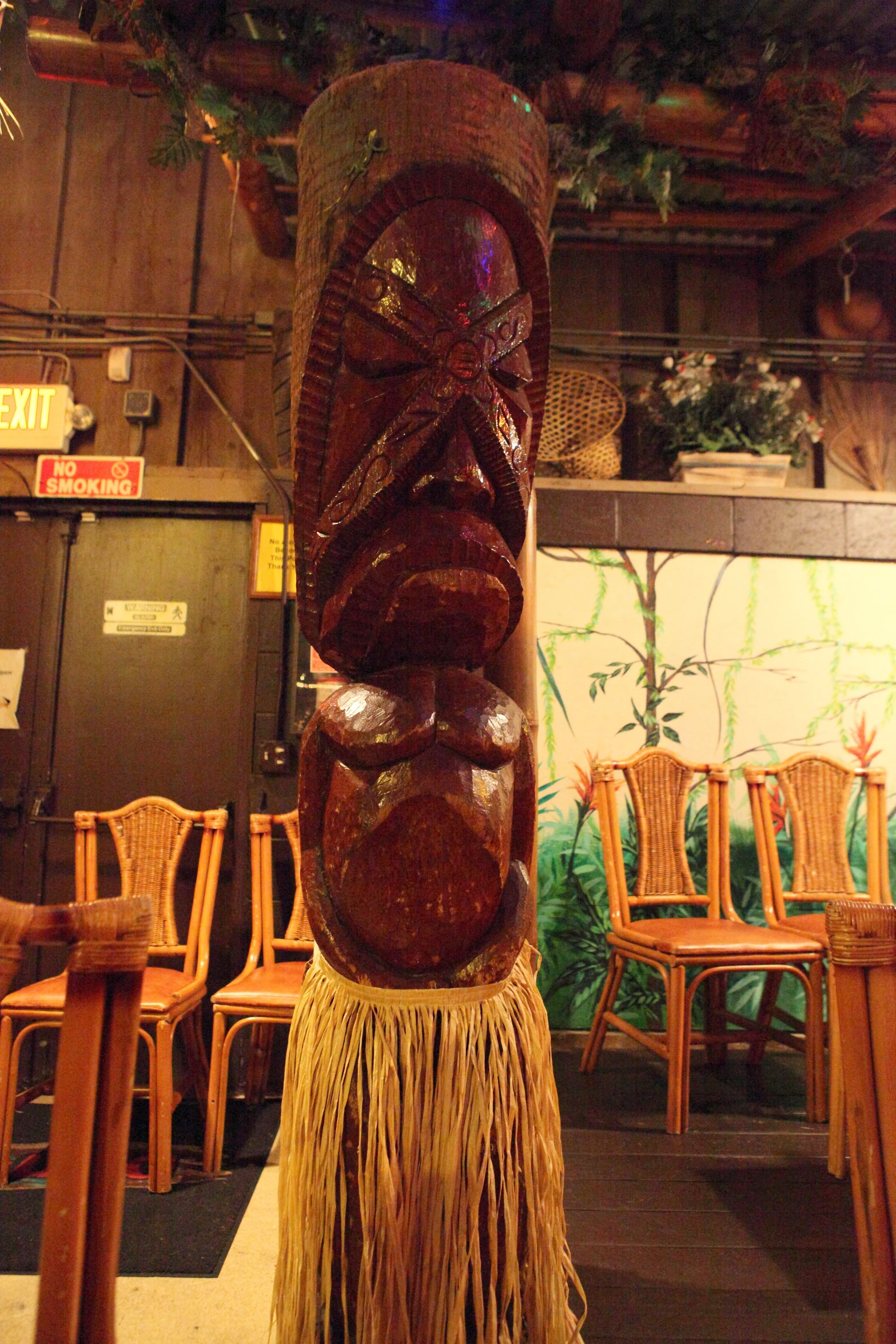 an tiki mask in front of many chairs