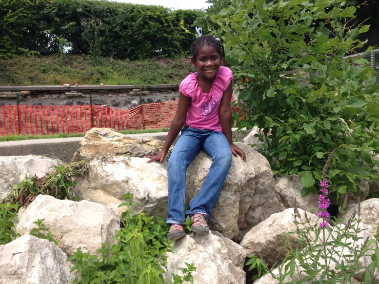 a girl posing for the camera on a rock formation