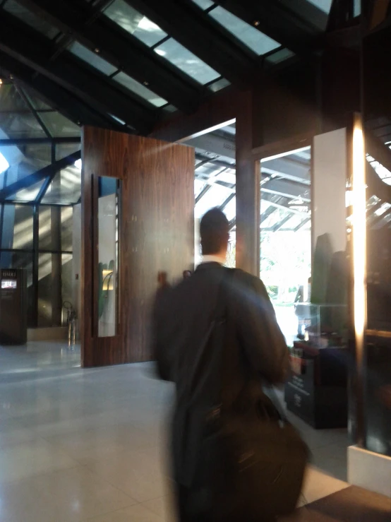 a man in grey shirt carrying luggage into the door