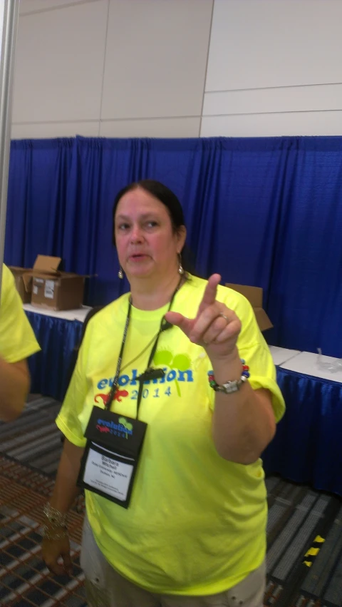 a woman in a yellow shirt pointing to soing