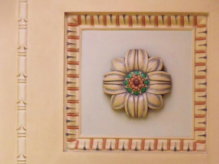 a wall hanging in a room with an ornamental flower