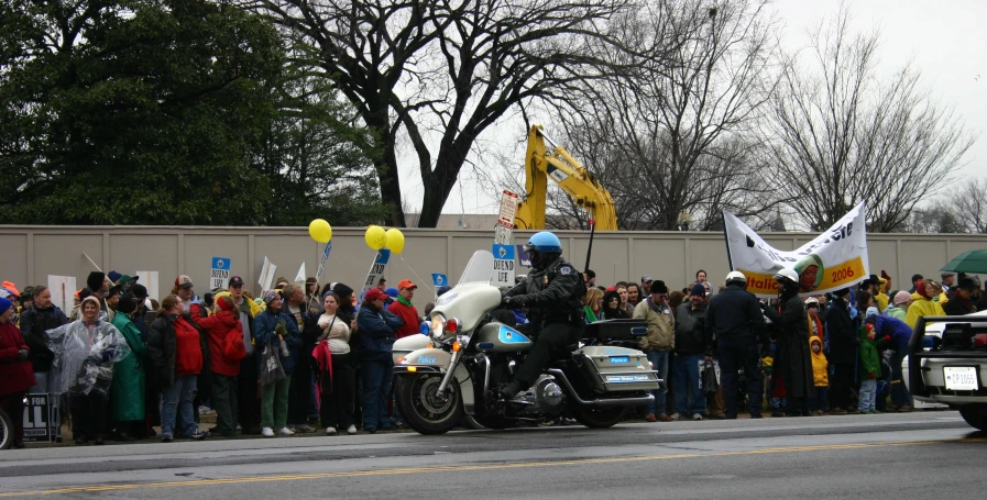 a large group of people standing around two motorcycles