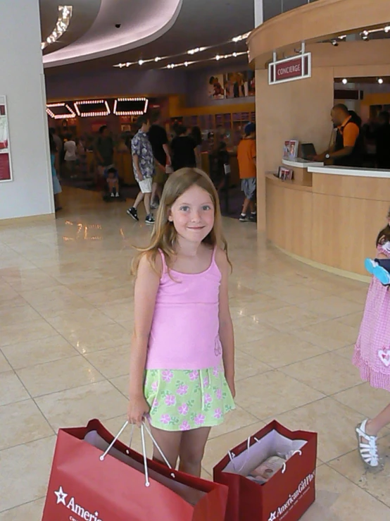 two s standing in a mall holding shopping bags