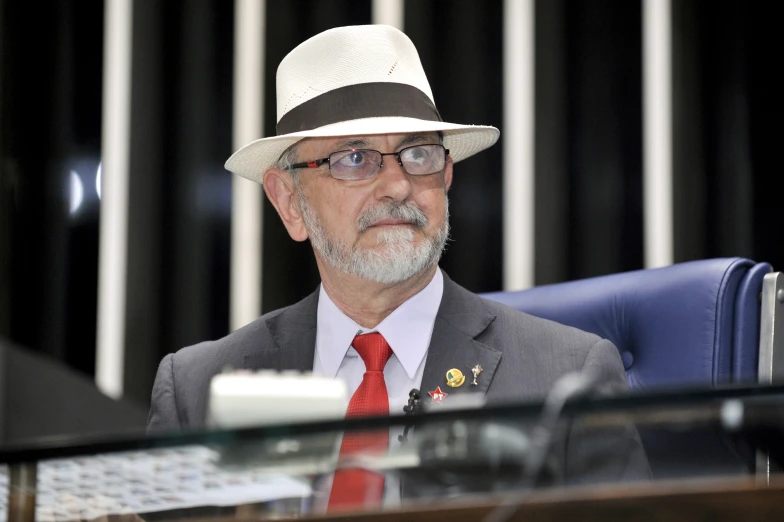 a man wearing a red tie and a white hat