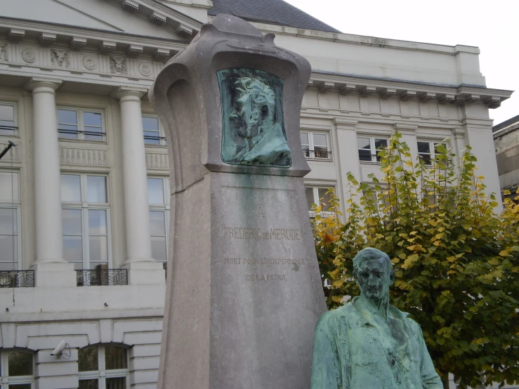 two statues in front of a building next to each other