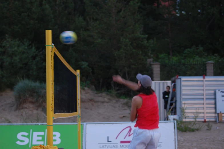 a person wearing a red shirt and white shorts is playing volley ball