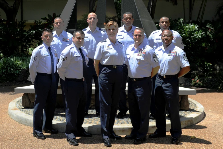 a group of pilots pose in front of the fountain