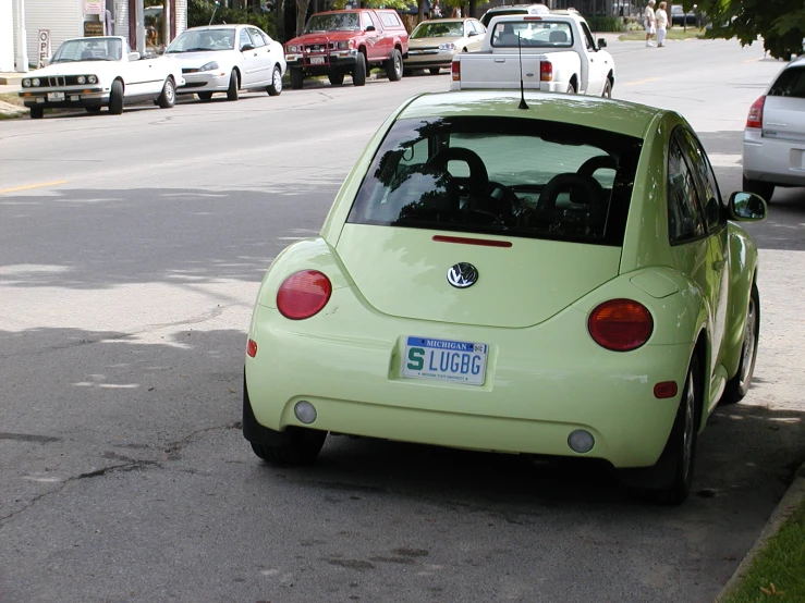 the beetle is parked in front of many other cars