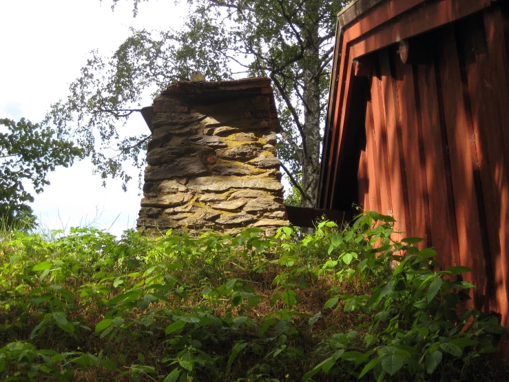 a brown and gray stone chimney near trees