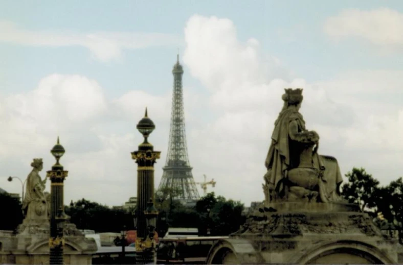 statues in front of the eiffel tower with a sky background