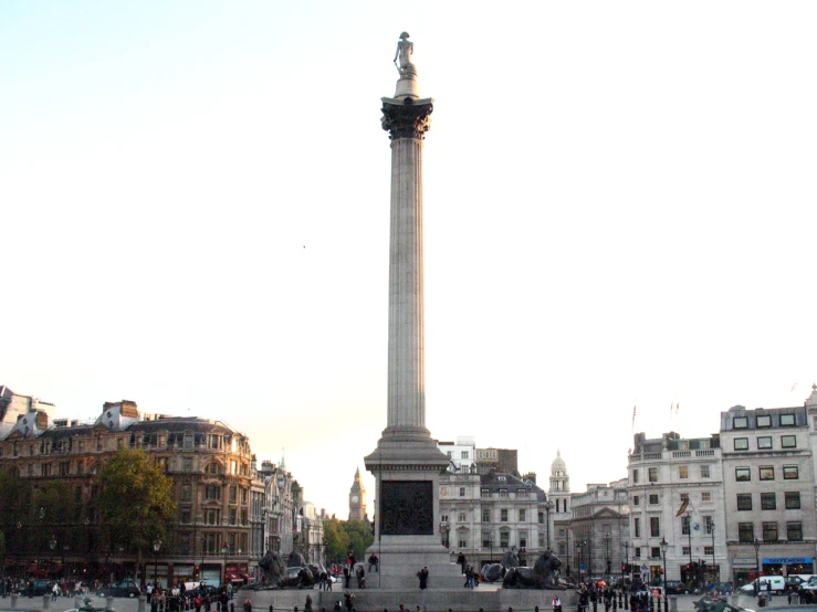 the monument of liberty stands in front of the city buildings