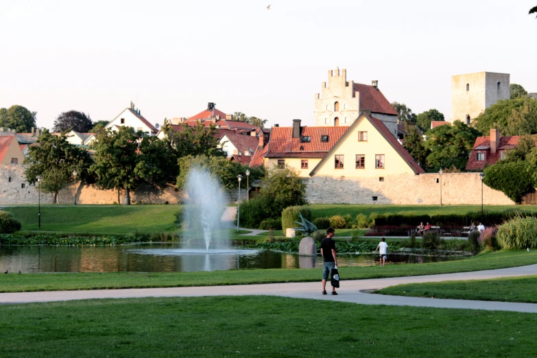 a view of people standing near water fountain and buildings