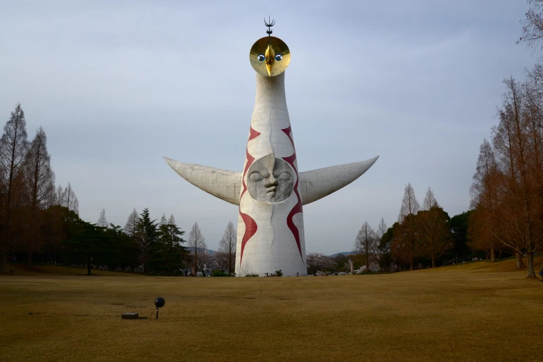 large, giant white object with gold and red accents and a man kneeling on the ground in front of it