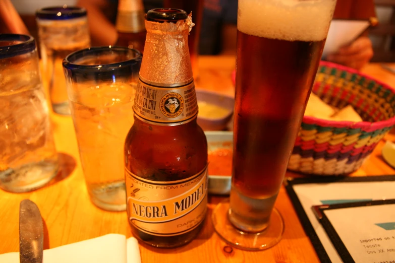 a close up of two beer bottles and a glass