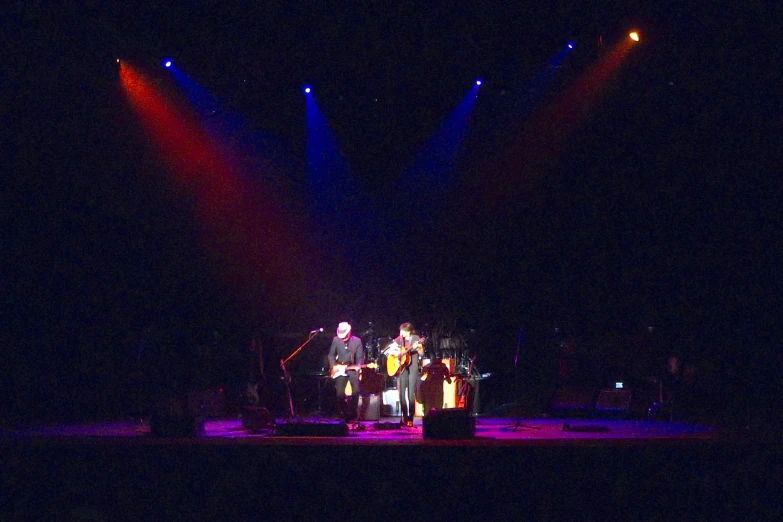 an image of group with instruments on stage at night