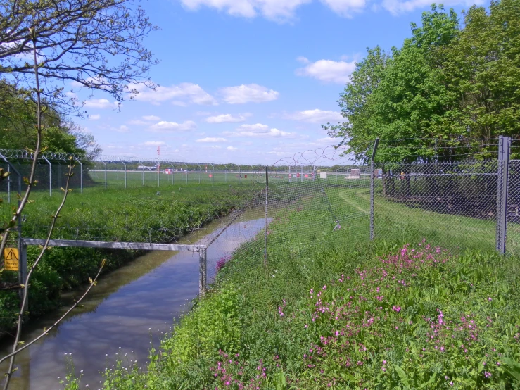 a view of a small canal with a fence around it