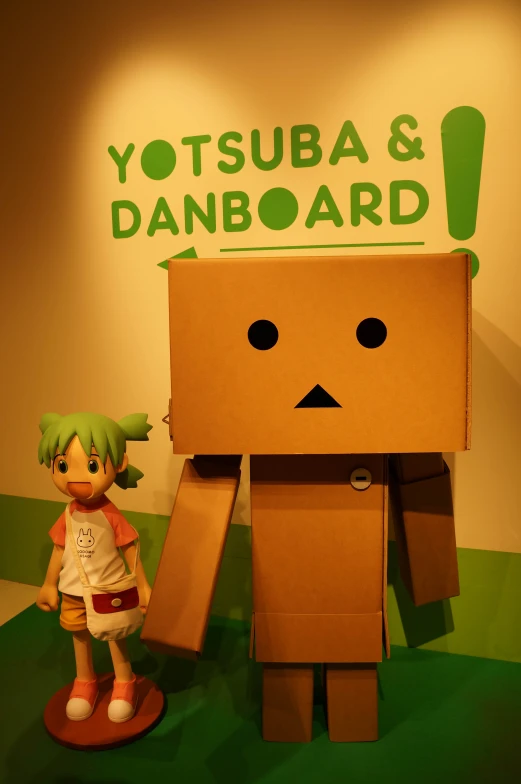 a cardboard toy next to a paper model of a box character