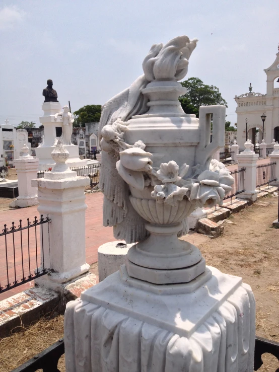 a large statue sits on the edge of a cemetery