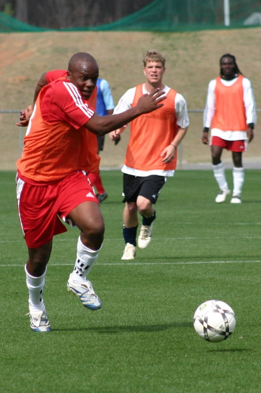 two soccer teams are running after a soccer ball