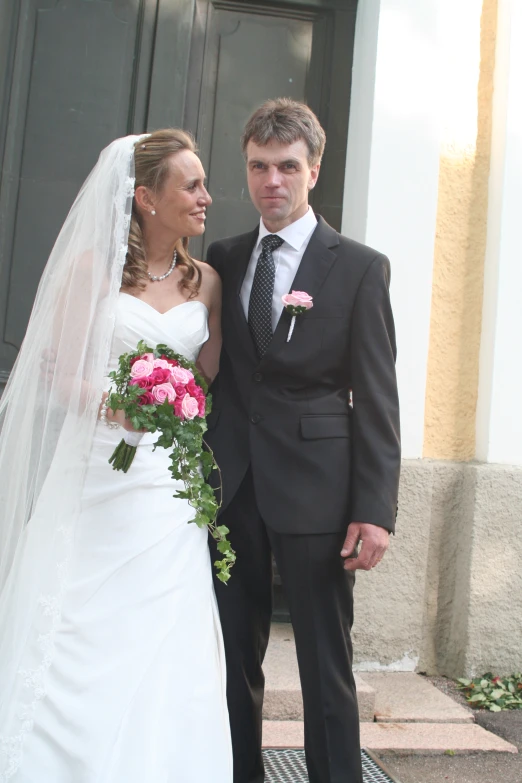 the bride and groom are standing outside of the church