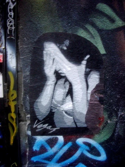 a mural with a picture of a woman covering her face