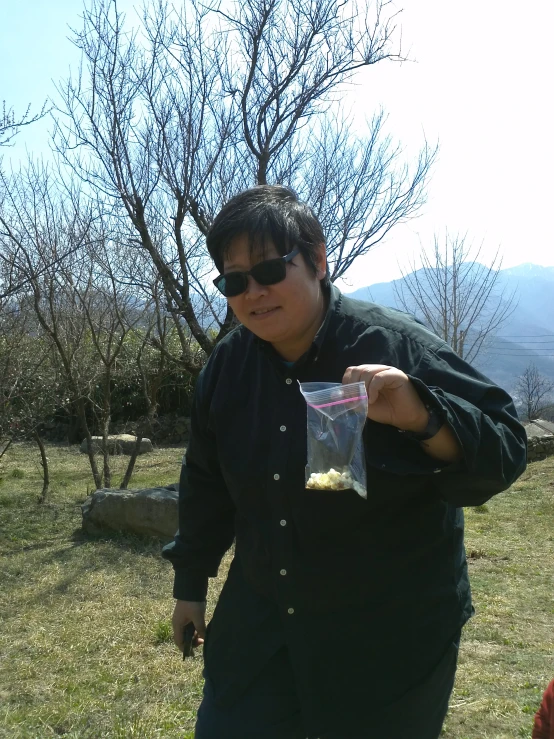 a woman holding up a piece of food in a field