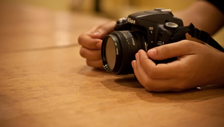 a person holding a camera and pointing it in to the lens