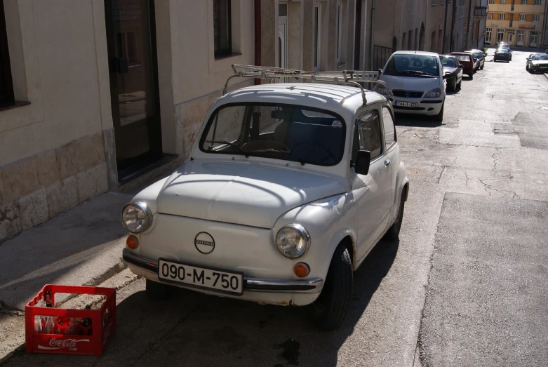 an old white car with ski rack on it parked