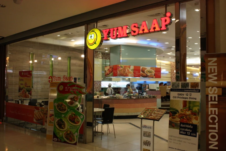 the restaurant with a yellow smiley face is sitting in a mall