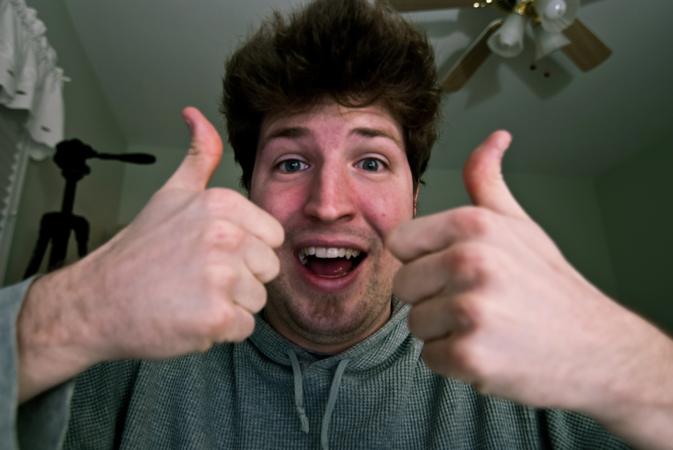 a young man points his thumbs to the camera