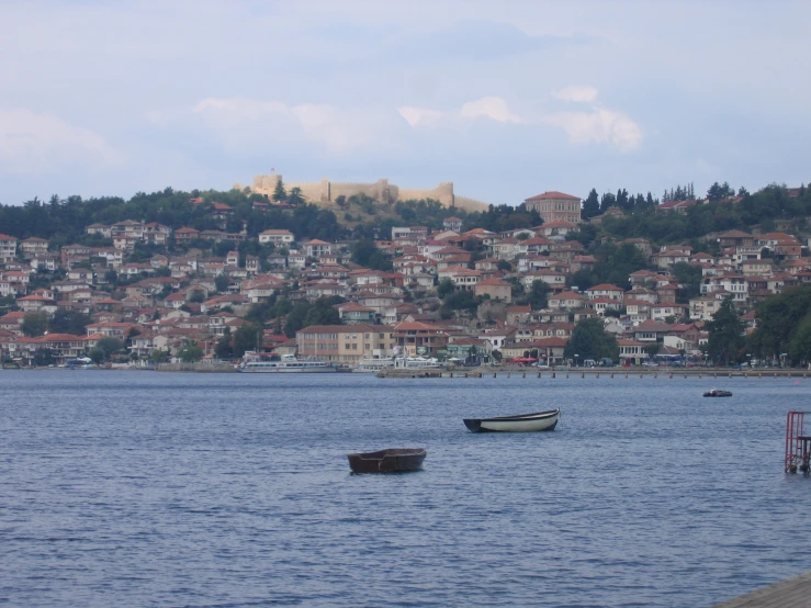 some boats in a harbor with city in the background