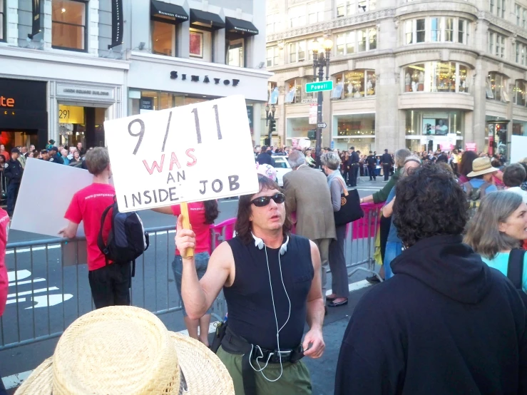 people standing outside with a man holding a sign that says 911 on