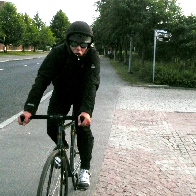 an image of a man riding his bike down the street