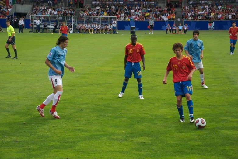 a group of boys in red and blue uniforms playing soccer