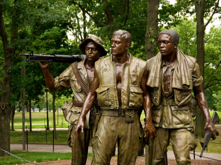 some statues of men holding guns standing outside