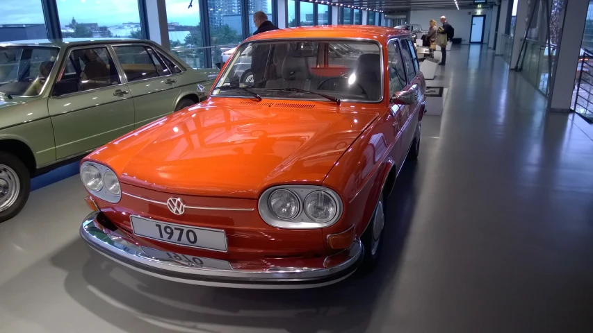 two old time cars parked in the show room