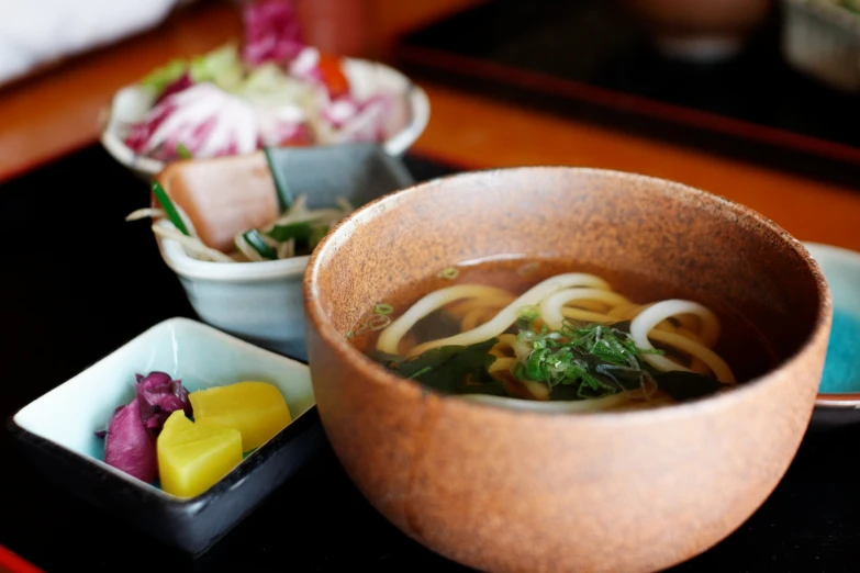 soup is prepared with noodles, vegetables, and other foods