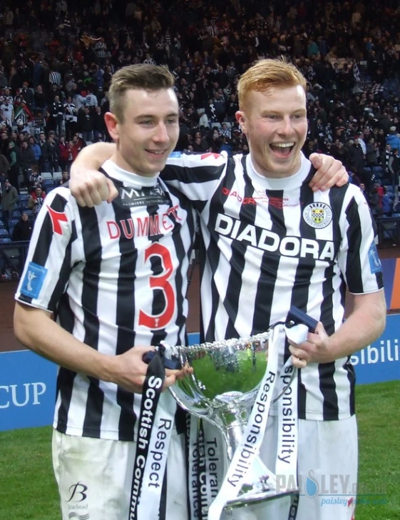 two soccer players standing next to each other with their arms around one another