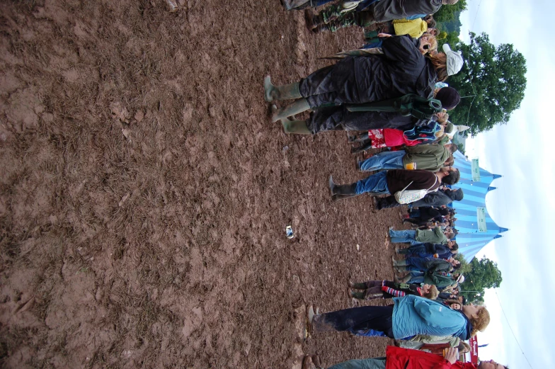 a crowd of people gathered in a muddy field