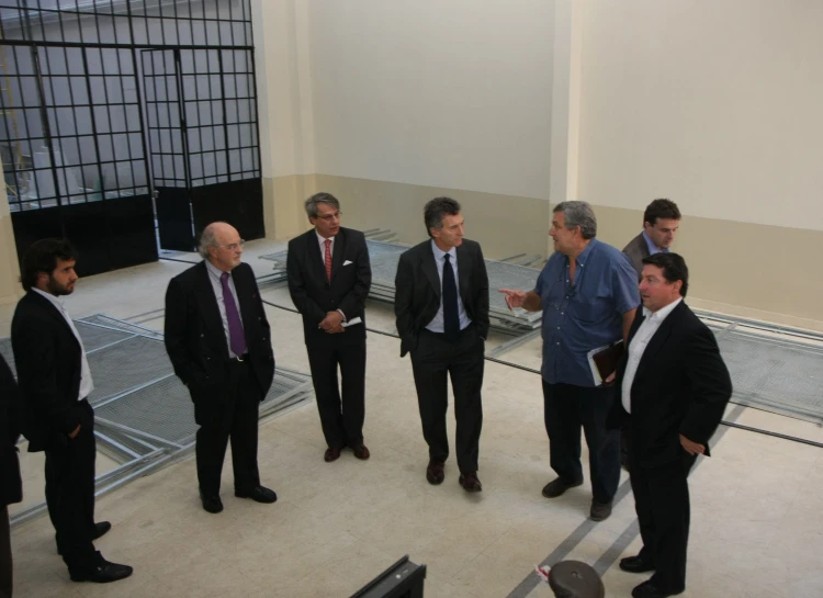 men in suits and ties standing in a room talking