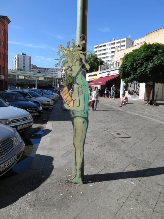 a woman in costume stands on a street pole