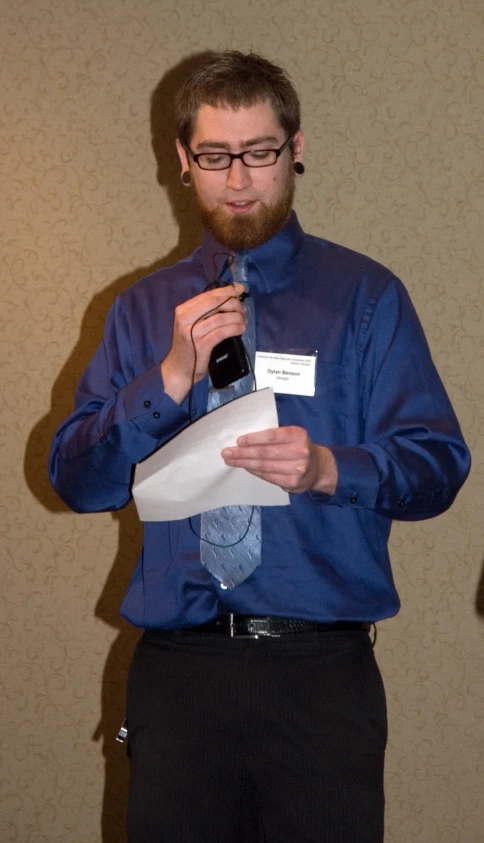 the man is in a blue shirt, tie and black pants