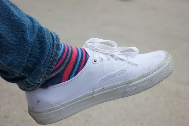 someone wearing socks and white sneakers