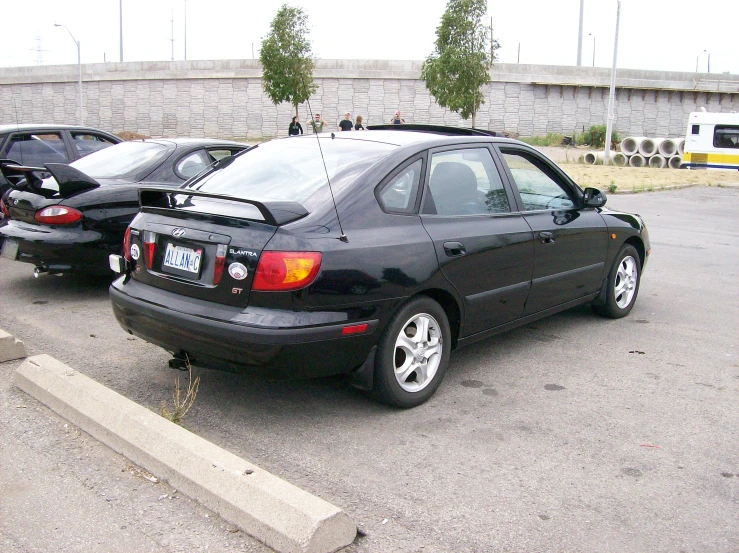 a small black car is parked in the lot