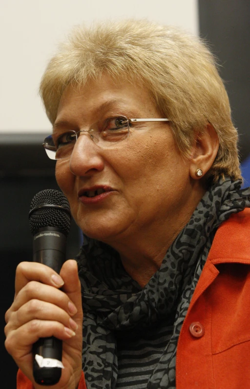 a woman with glasses is holding a microphone