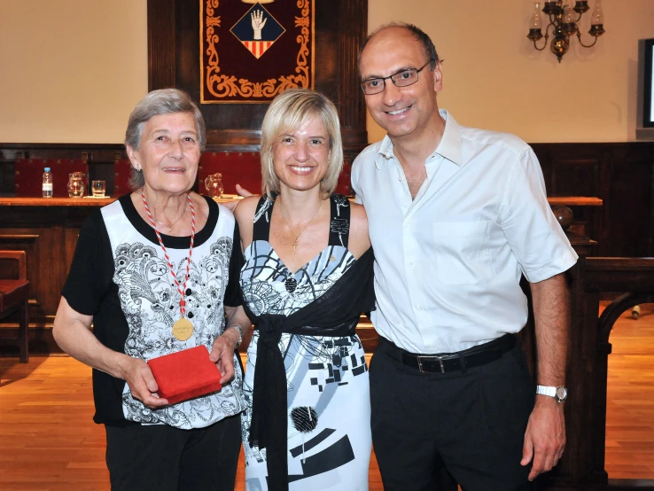 two women and a man smiling at the camera