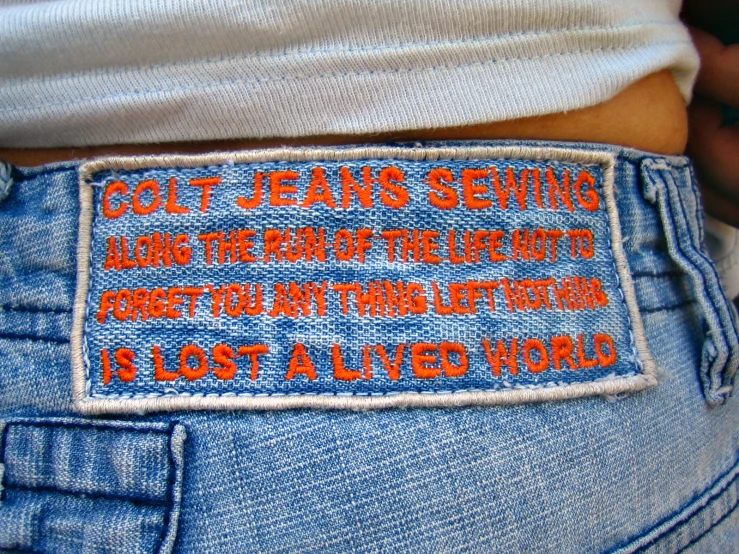 a close up of an orange patch on some jeans